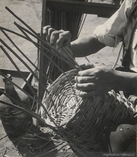 Artesano tejiendo mimbre, hacia 1960.