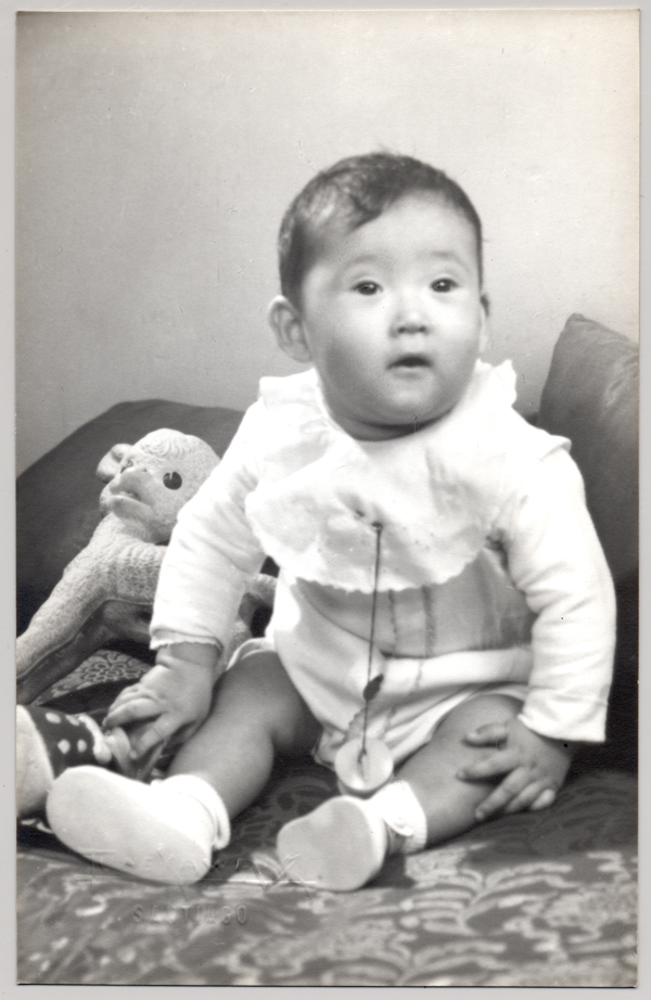 [Bebé de rasgos asiáticos, vestido completamente de blanco)
