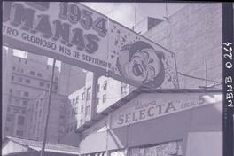 [Letrero que anuncia el Circo Las Aguilas Humanas 1954, y librerias de viejo instaladas en la calle]
