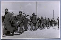 [Grupo de refugiados españoles, caminando con palas en sus hombros, en el campo de Bacares, Francia]