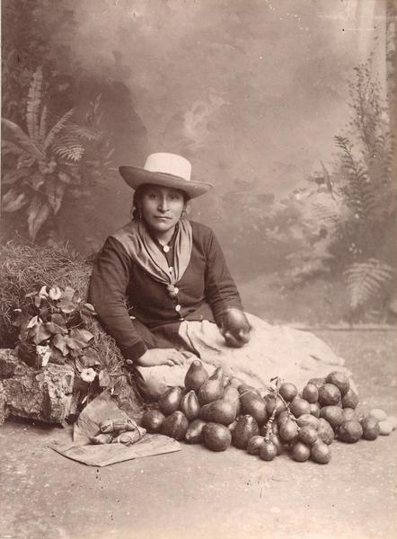 [Retrato de mujer peruana sentada junto a verduras]
